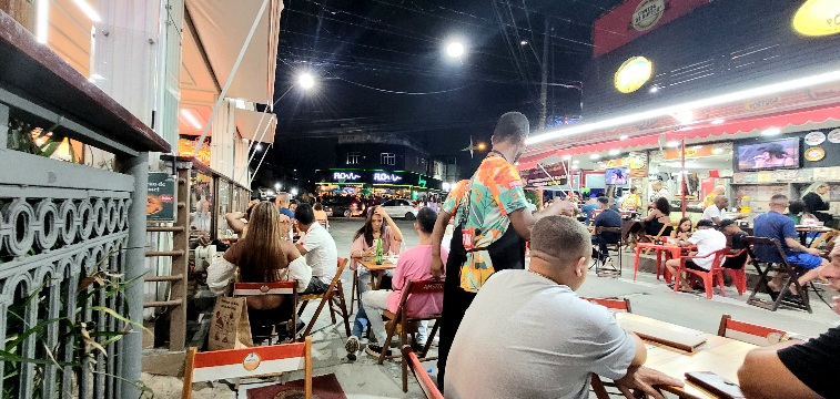 Rua da lama com vários bares e pessoas